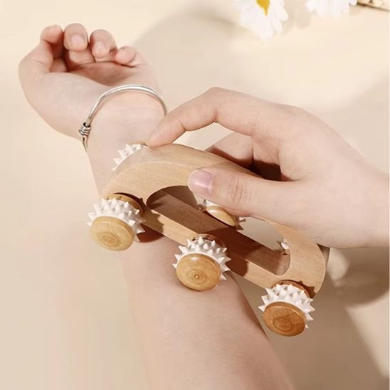 rouleau de massage en bois sur le bras