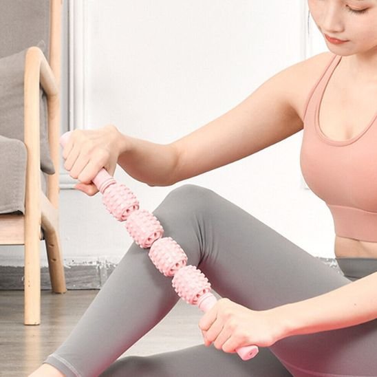 rouleau de massage rose sur jambes